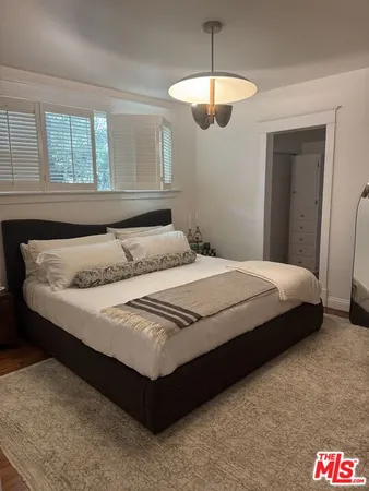 a bedroom with a bed and a chandelier