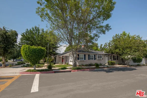 a front view of a house with a yard and potted plants