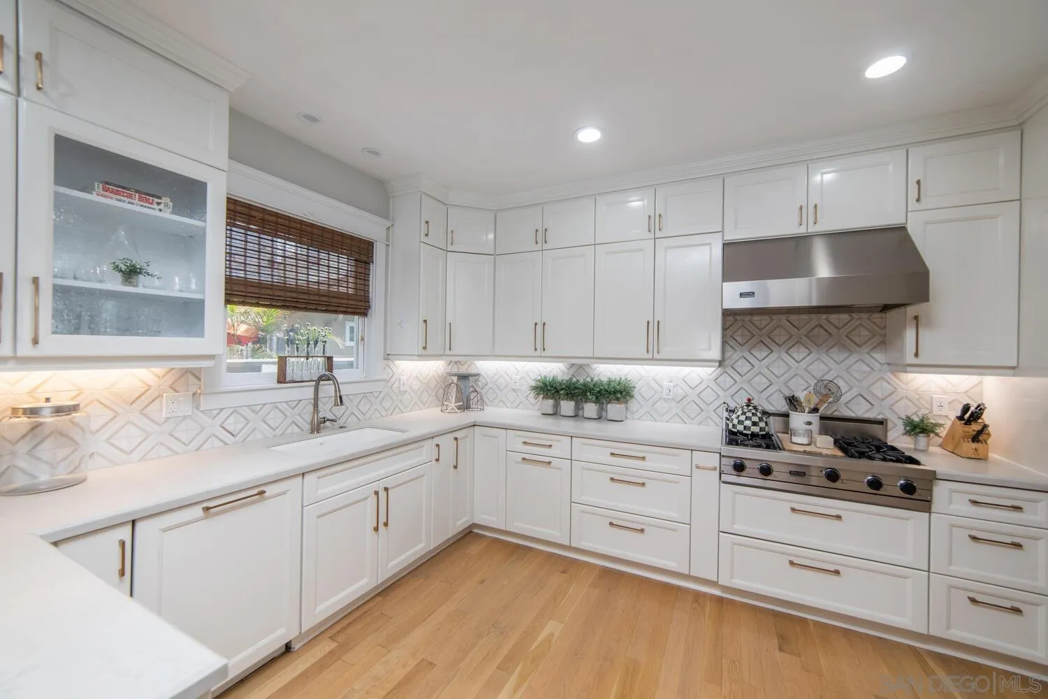 717 G Avenue Coronado, CA 92118 - Photo 9 of 33 a kitchen with granite countertop white cabinets and white appliances