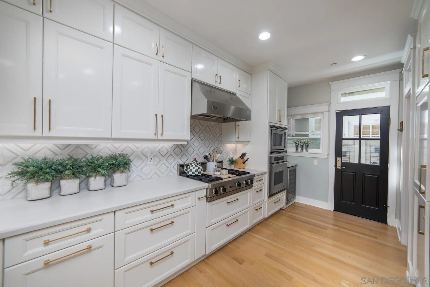 717 G Avenue Coronado, CA 92118 - Photo 10 of 33 a kitchen with stainless steel appliances kitchen island granite countertop a sink a stove and cabinets
