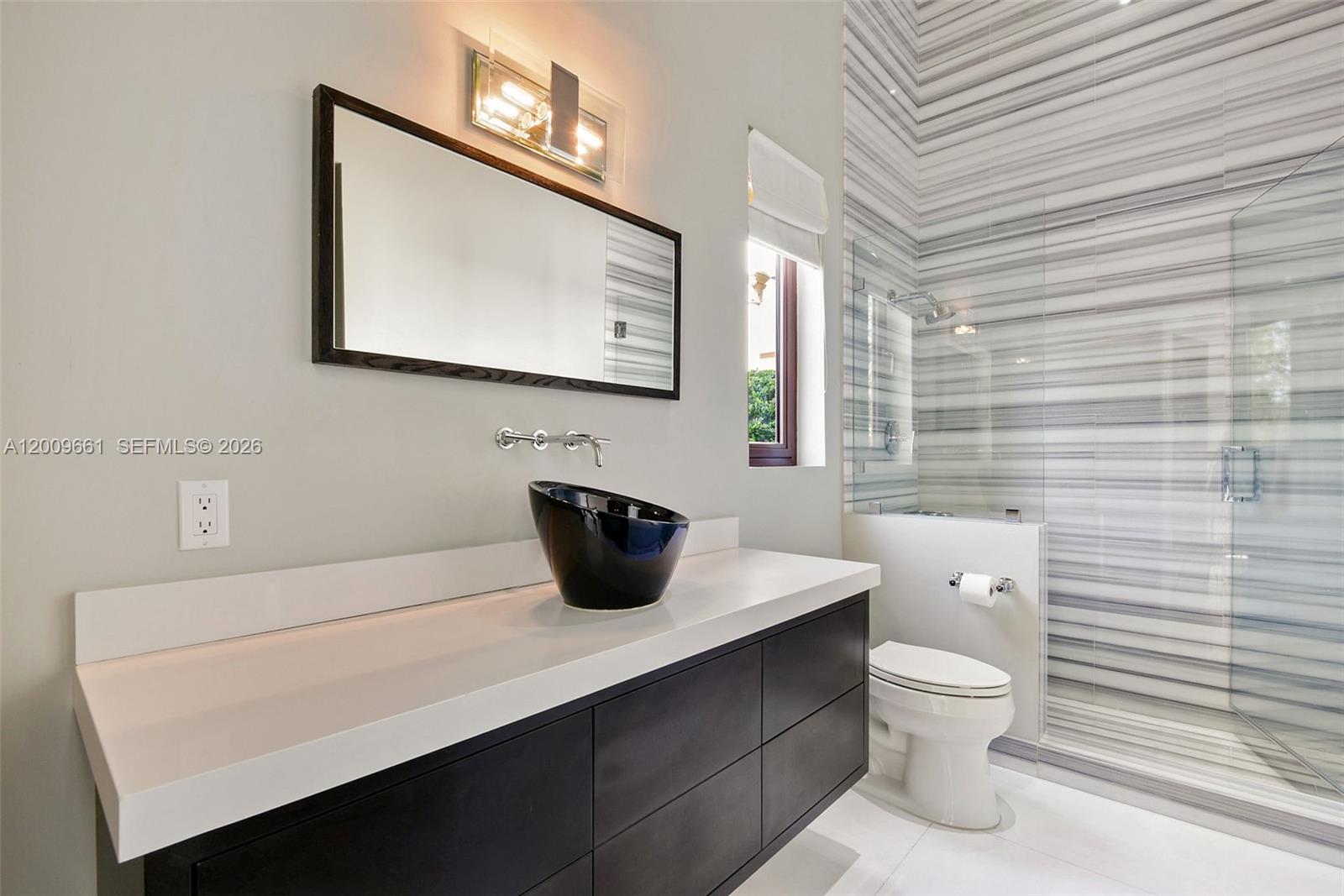 5801 Moss Ranch Road Pinecrest, FL 33156 - Photo 11 of 32 a bathroom with a toilet sink and mirror