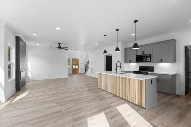 a large kitchen with stainless steel appliances kitchen island a large counter top and a stove top oven