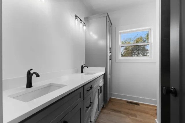 a bathroom with a double vanity sink and mirror