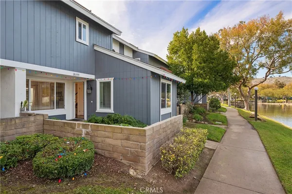 a front view of a house with a yard and potted plants