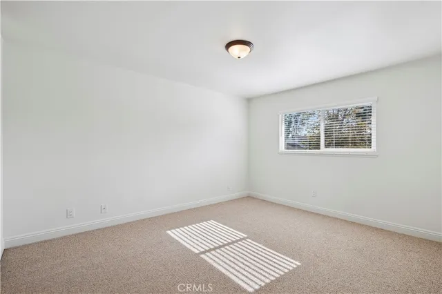 an empty room with a piano and a window
