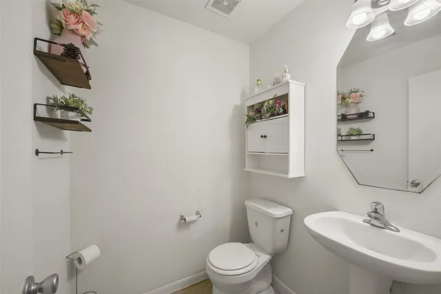 a bathroom with a toilet a sink and mirror