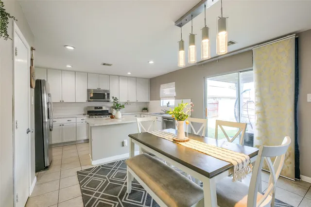 a kitchen with stainless steel appliances kitchen island granite countertop a refrigerator and a stove top oven