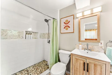 a bathroom with a sink a toilet and a mirror