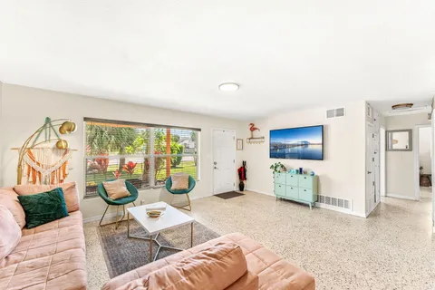 a kitchen with stainless steel appliances granite countertop a stove a sink dishwasher and a refrigerator with white cabinets