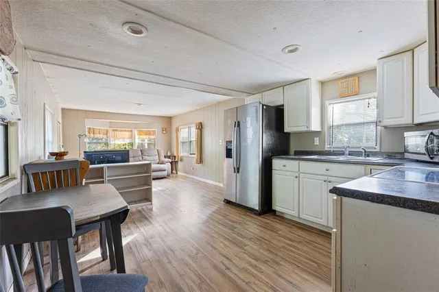 a kitchen with white cabinets stainless steel appliances and a window
