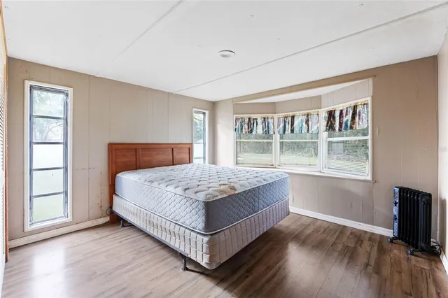 a bedroom with a bed and wooden floor
