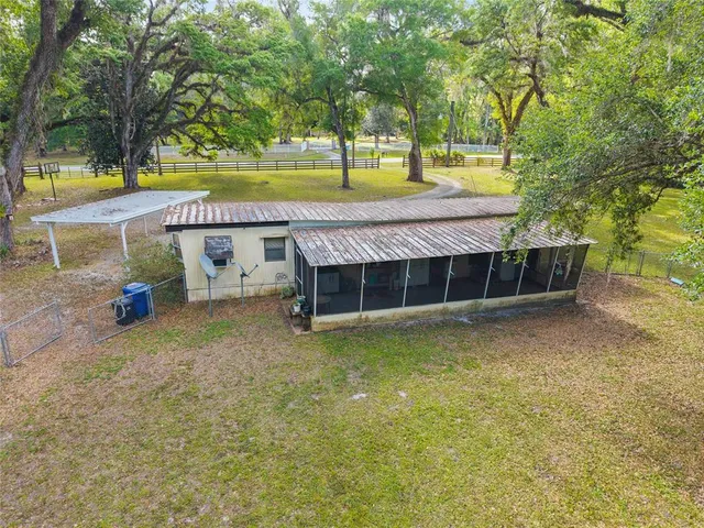 a view of a house with a yard and large tree