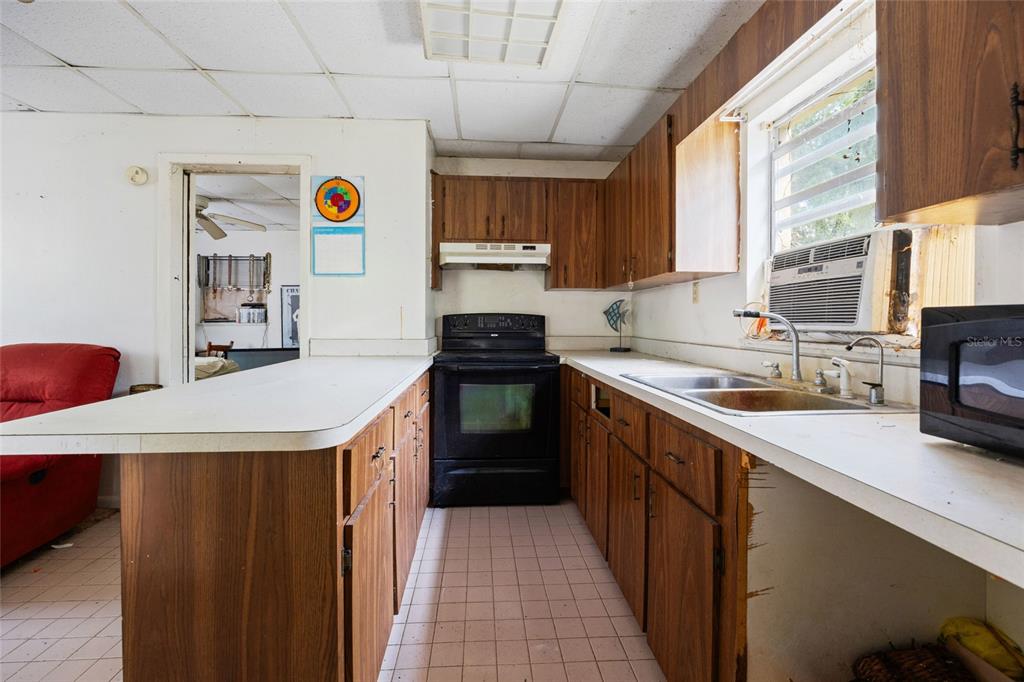 2780 County Road 575 Bushnell, FL 33513 - Photo 34 of 57 a kitchen with a sink a stove top oven a refrigerator and a window