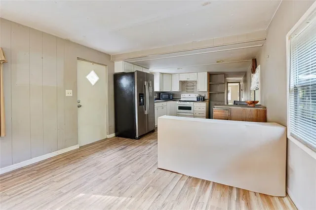 a kitchen with a wooden floor and a fireplace