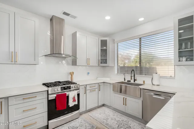 a kitchen with granite countertop a sink stove top oven and cabinets