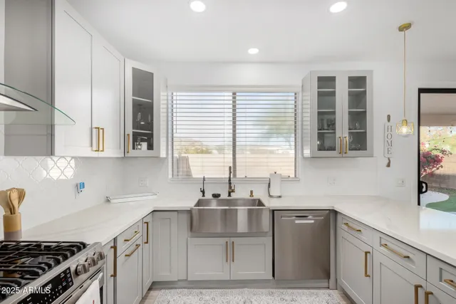 a kitchen with stainless steel appliances a sink stove and cabinets