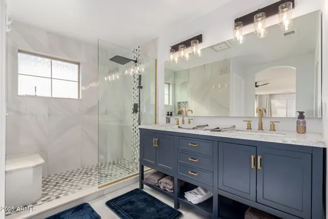 a bathroom with a double vanity sink mirror and shower