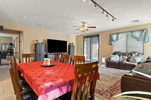 a kitchen with a refrigerator a kitchen island and chairs in it
