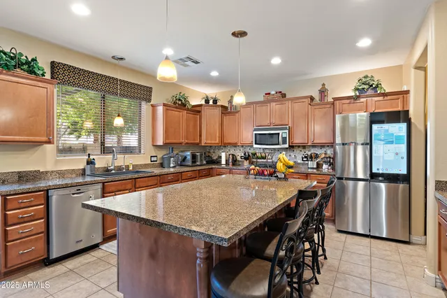 a open dining room with stainless steel appliances granite countertop a sink a stove a dining table and chairs
