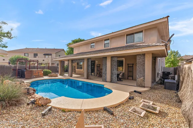 a view of a house with swimming pool and sitting area