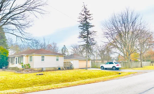 a view of a house with a big yard and large trees