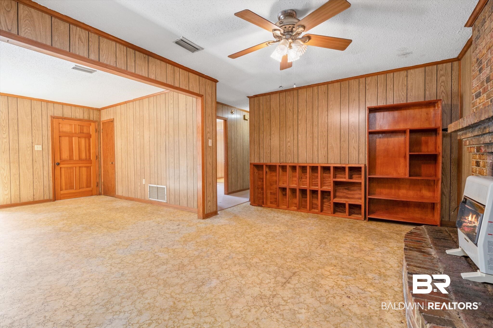 1456 Herman Williams Road Fruitdale, AL 36539 - Photo 6 of 24 Living room with ceiling fan, wooden walls, and light colored carpet