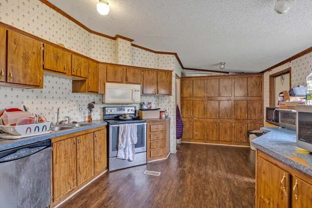 a kitchen with granite countertop a sink cabinets and wooden floor