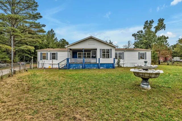 a front view of a house with a garden and sitting area
