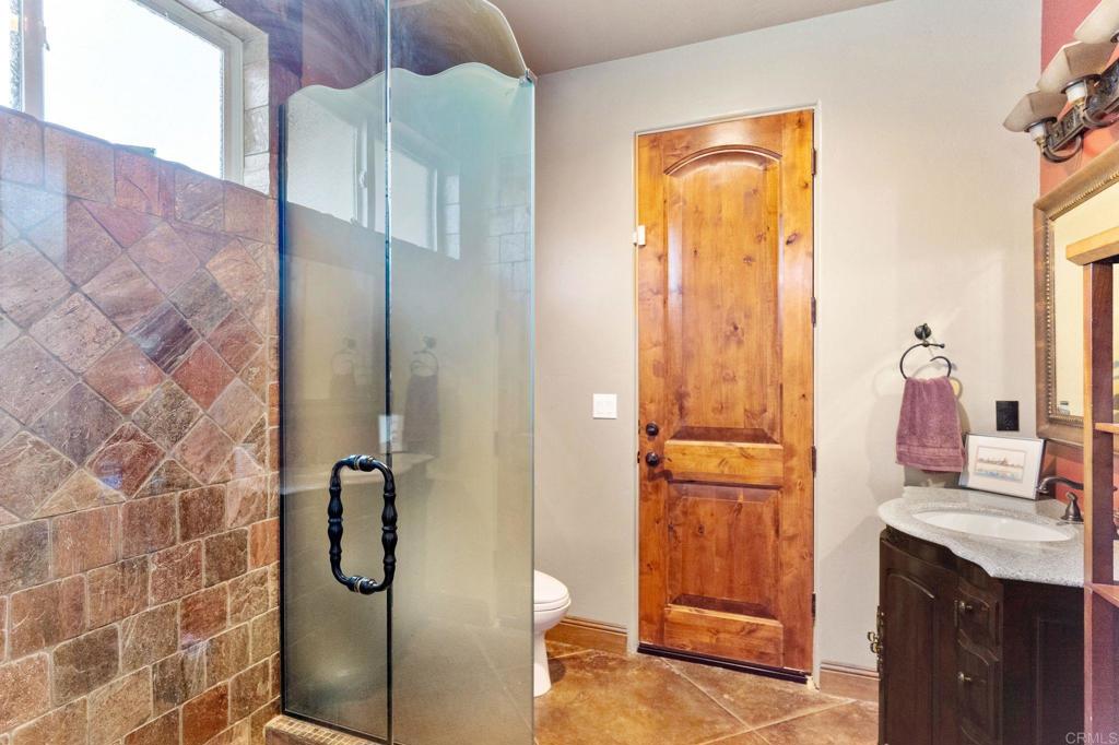 9746 Megan Escondido, CA 92026 - Photo 31 of 65 a bathroom with a granite countertop shower a mirror and a sink