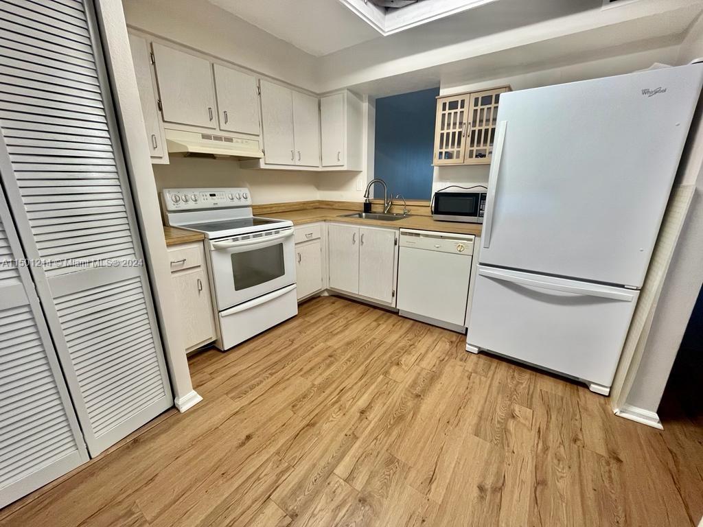 357 North Rock Island Road, Unit 304 Margate, FL 33063 - Photo 3 of 20 a kitchen with wooden floors and white appliances