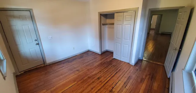an empty room with wooden floor and closet