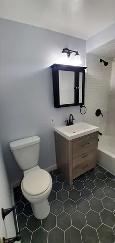 a bathroom with a toilet a sink and mirror