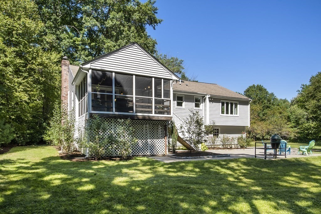 221 Red Acre Road Stow, MA 01775 - Photo 26 of 28 a front view of a house with a yard table and chairs