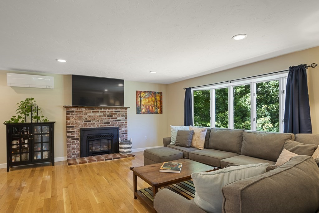 221 Red Acre Road Stow, MA 01775 - Photo 3 of 28 a living room with furniture a fireplace and a flat screen tv