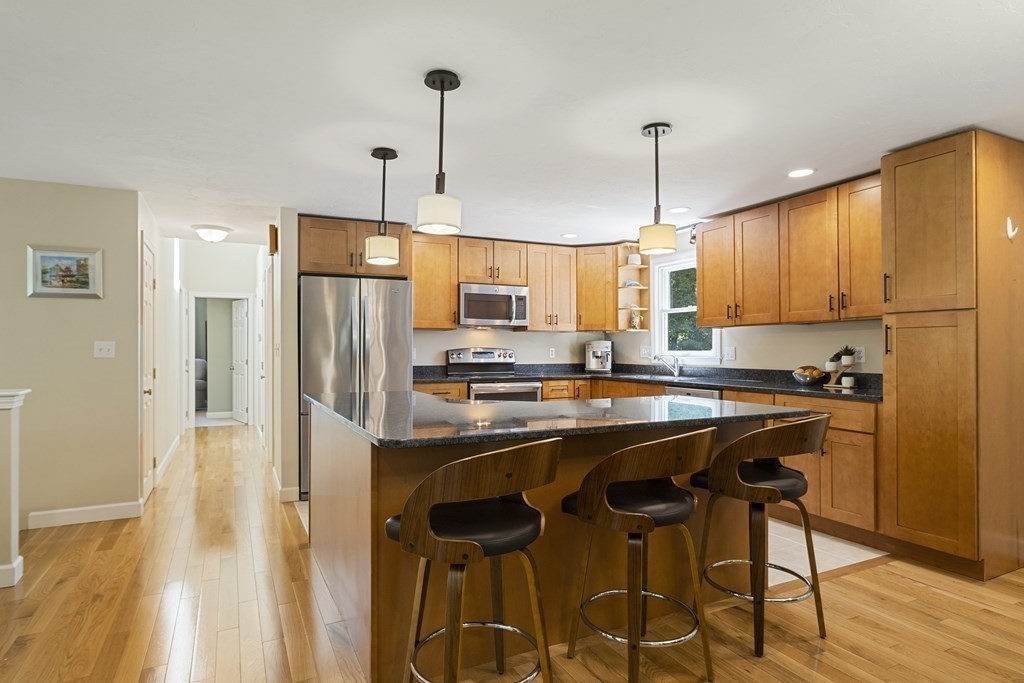 221 Red Acre Road Stow, MA 01775 - Photo 7 of 28 a kitchen with stainless steel appliances granite countertop a sink a stove a refrigerator and island with wooden floor