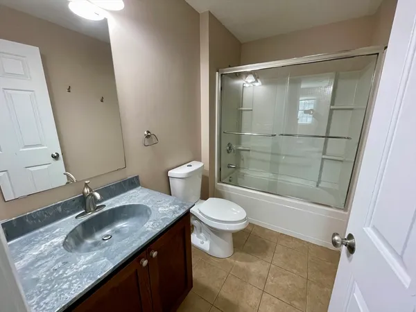 a bathroom with a granite countertop sink toilet and shower