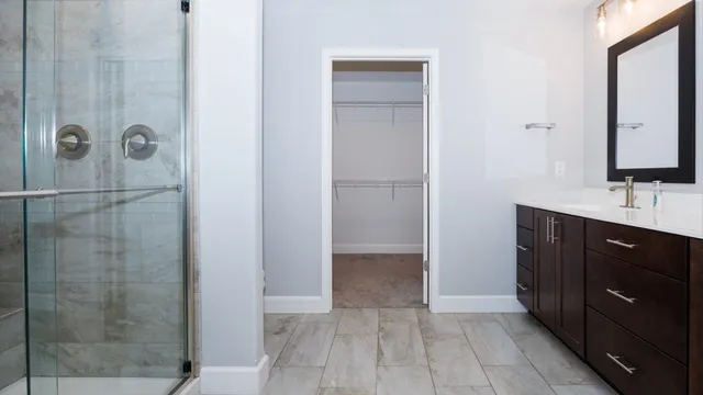 a bathroom with a double vanity sink a mirror and shower