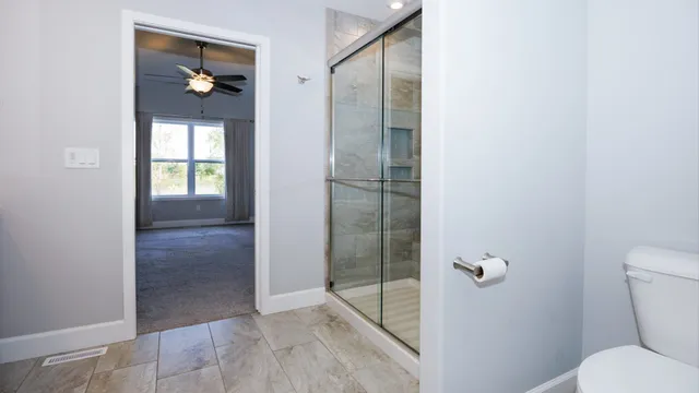a bathroom with a granite countertop shower and toilet