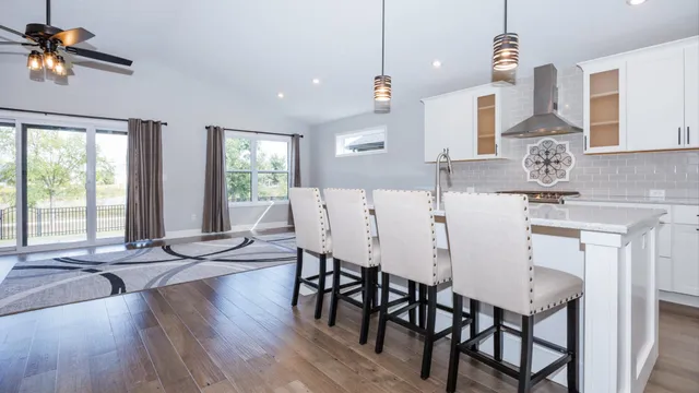 a kitchen with stainless steel appliances granite countertop a dining table chairs stove a sink and dishwasher