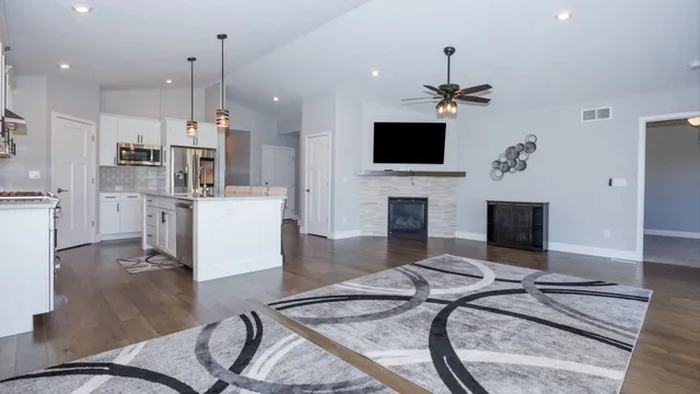 a living room with furniture a flat screen tv and a fireplace