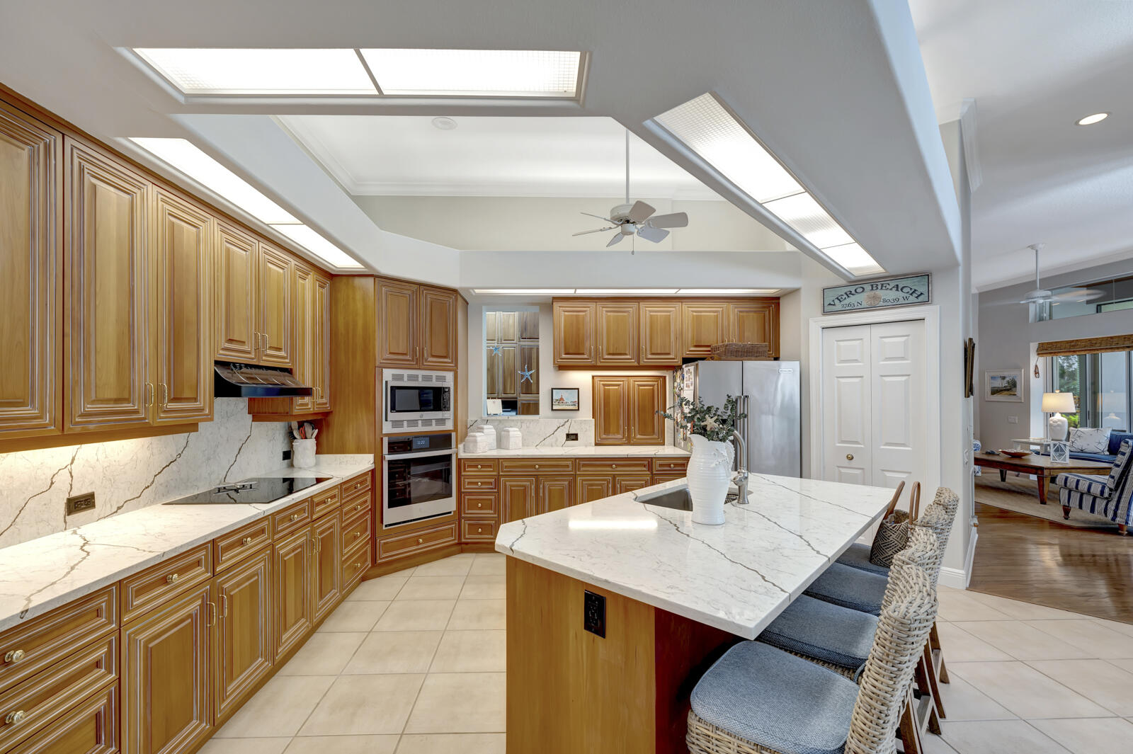 201 Seaside Pathway Vero Beach, FL 32963 - Photo 45 of 53 a open kitchen with stainless steel appliances kitchen island granite countertop a sink dishwasher a stove a refrigerator with a dining table and chairs