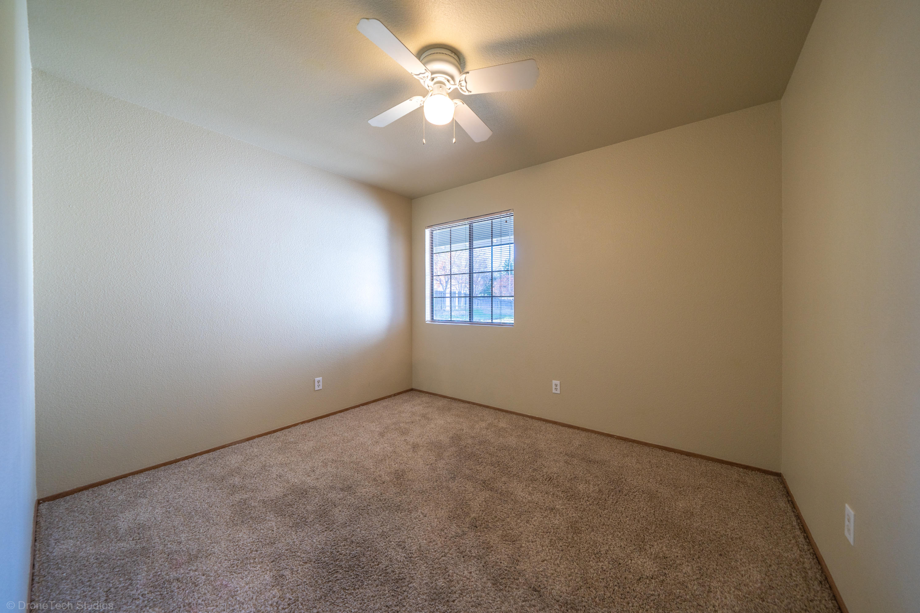 3645 Santa Rosa Way Redding, CA 96003 - Photo 25 of 48 an empty room with a chandelier fan and windows