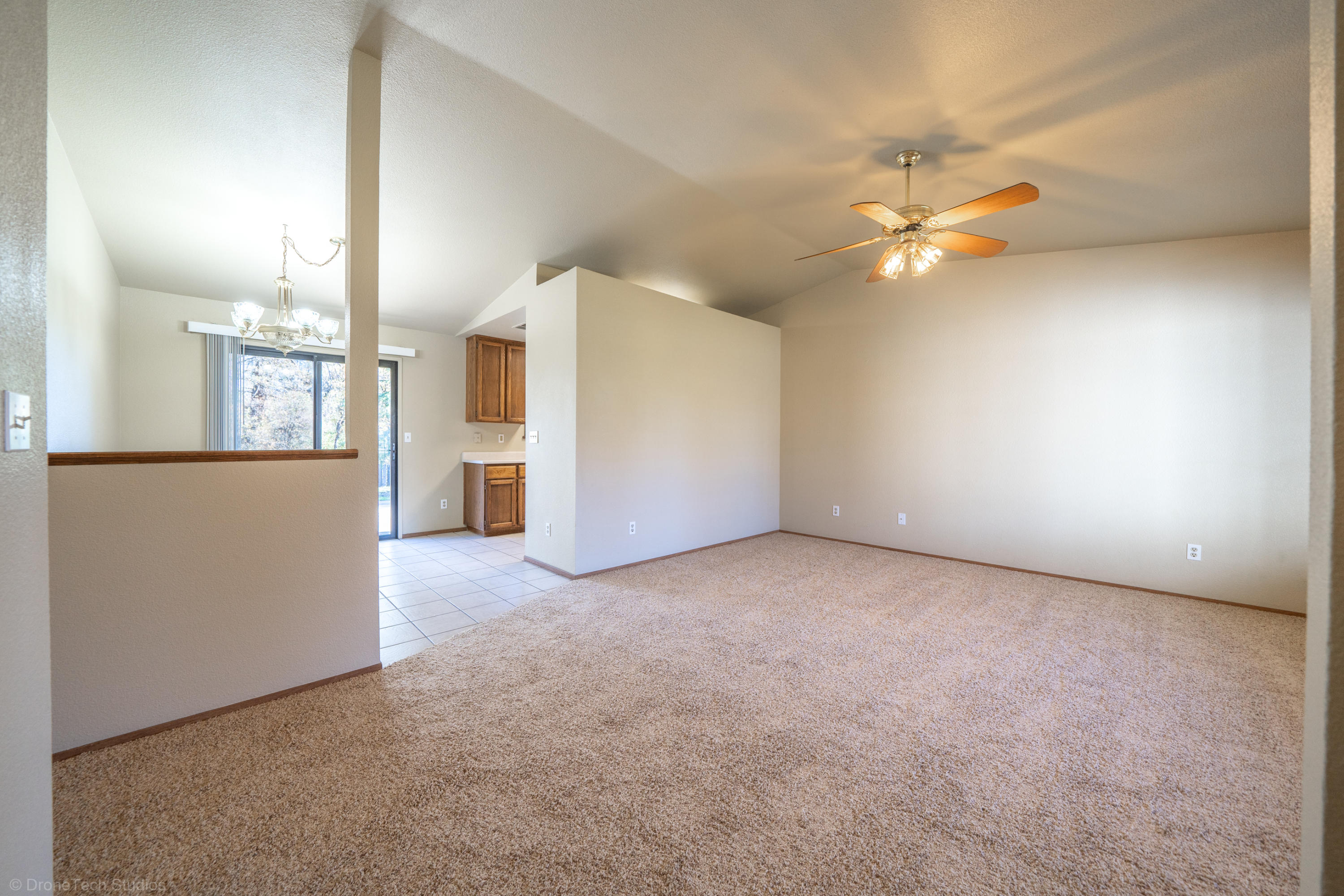 3645 Santa Rosa Way Redding, CA 96003 - Photo 7 of 48 an empty room with a kitchen and a ceiling fan