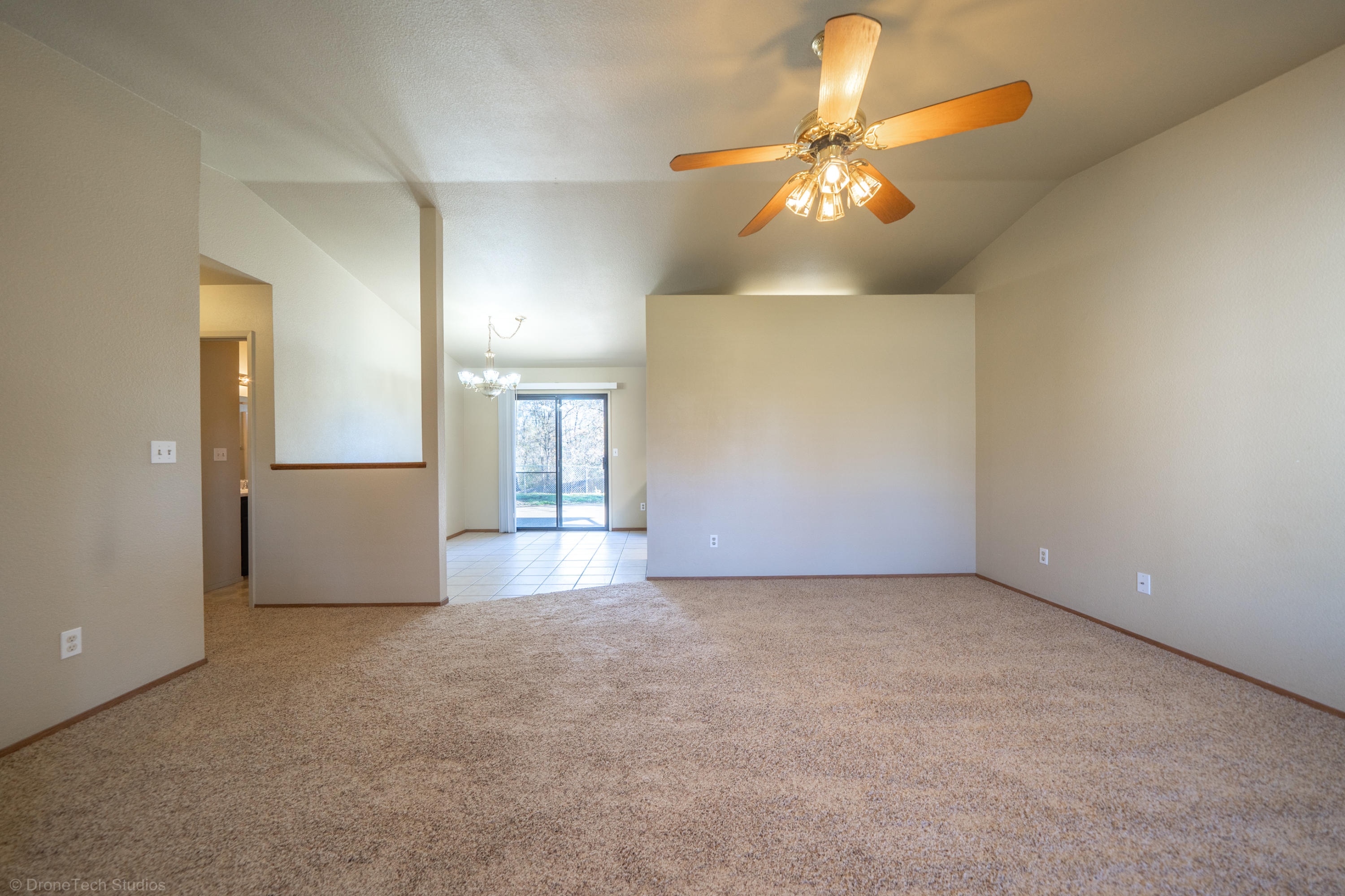 3645 Santa Rosa Way Redding, CA 96003 - Photo 8 of 48 an empty room with a chandelier fan and a large window
