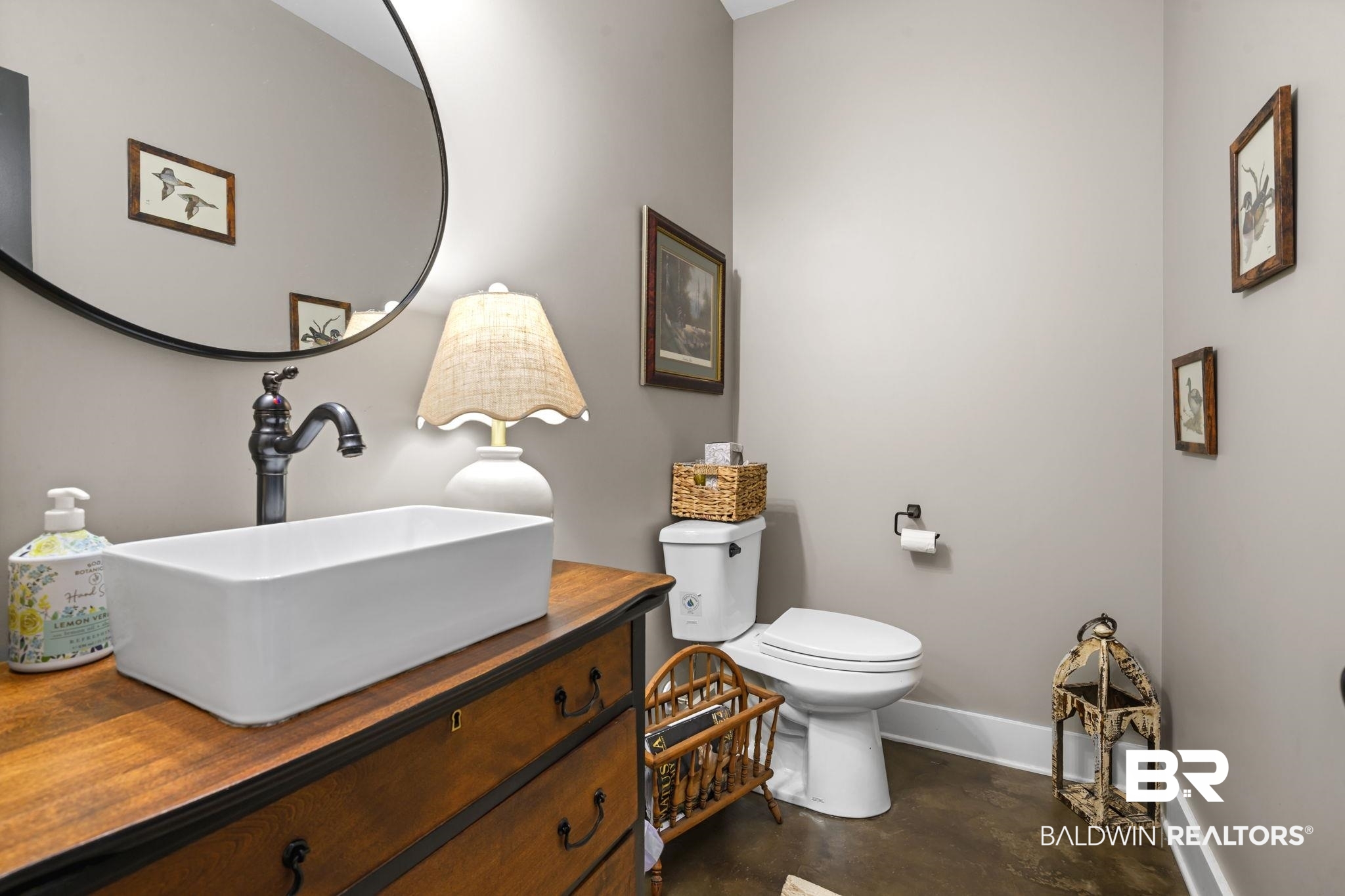 11025 Creax Road Axis, AL 36505 - Photo 20 of 45 Powder room featuring a rectangular vessel sink with dark bronze faucet, a black-framed circular mirror, and a wood-finish vanity