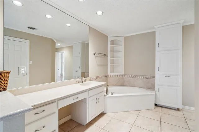 a bathroom with a tub sink shower and a mirror