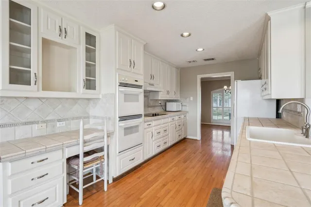 a kitchen with stainless steel appliances cabinets and a wooden floor