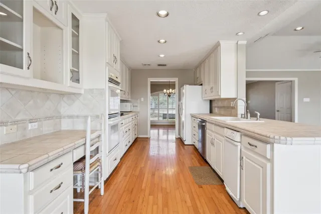 a large kitchen with stainless steel appliances granite countertop a lot of counter space and wooden floor