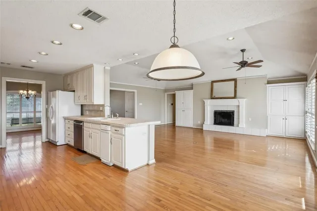a large kitchen with cabinets wooden floor and stainless steel appliances