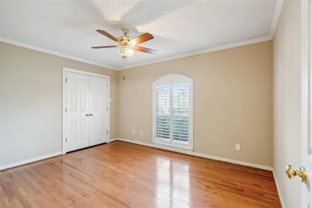 an empty room with windows and fan